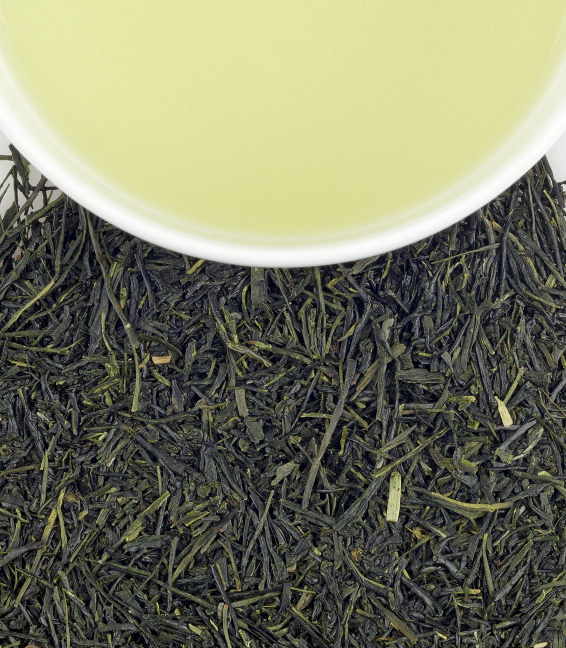 Organic Sencha green tea leaves with a cup of brewed tea, showcasing vibrant green color and rich texture.