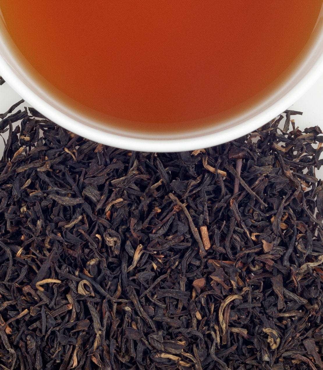A close-up of Panyang Congou black tea leaves with a cup of brewed tea above, showcasing rich color and texture.