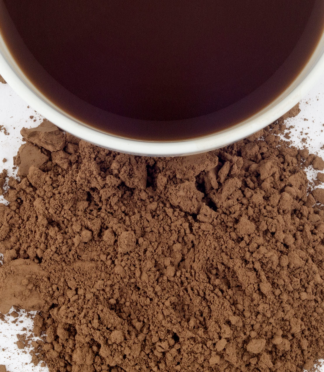 Ground Hojicha powder beside a cup of brewed Hojicha tea, showcasing its rich brown color and texture.
