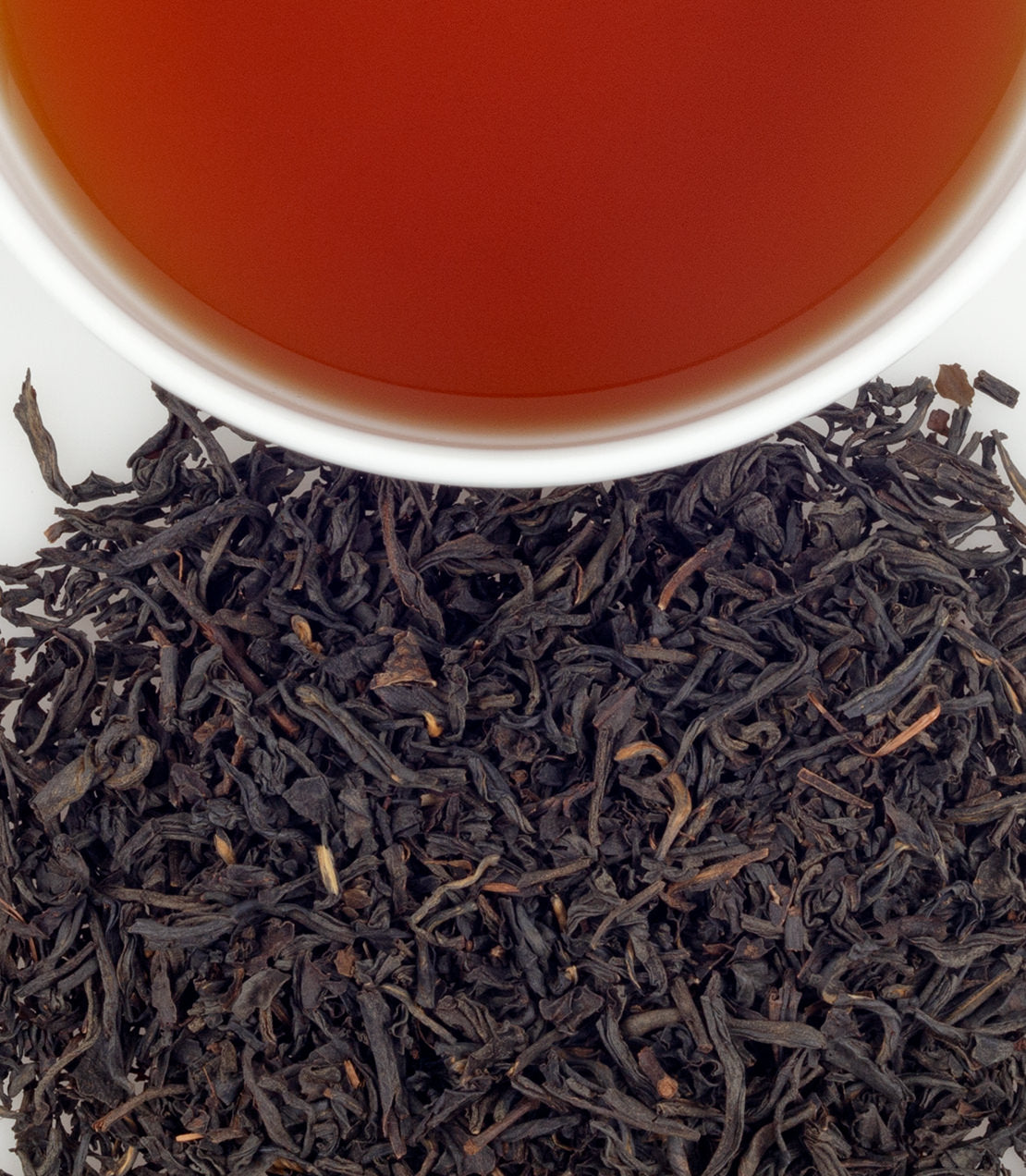 Queen Catherine tea sachets, 50-pack, with loose black tea leaves and brewed tea in a cup.