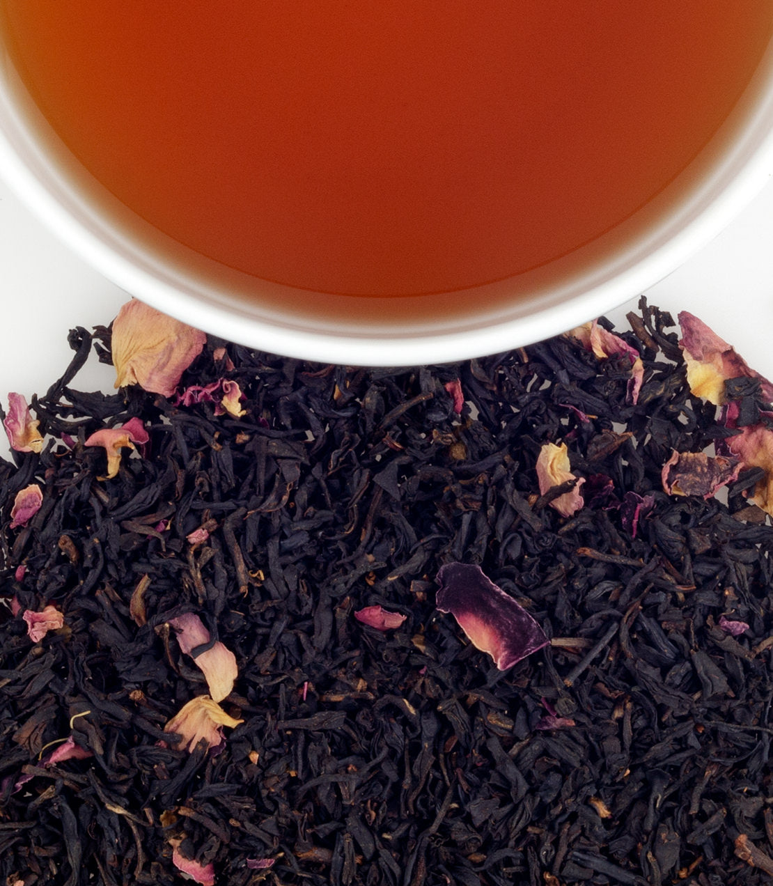 Rose-scented tea sachets with dried rose petals, accompanied by a cup of brewed tea. Perfect for a fragrant experience.