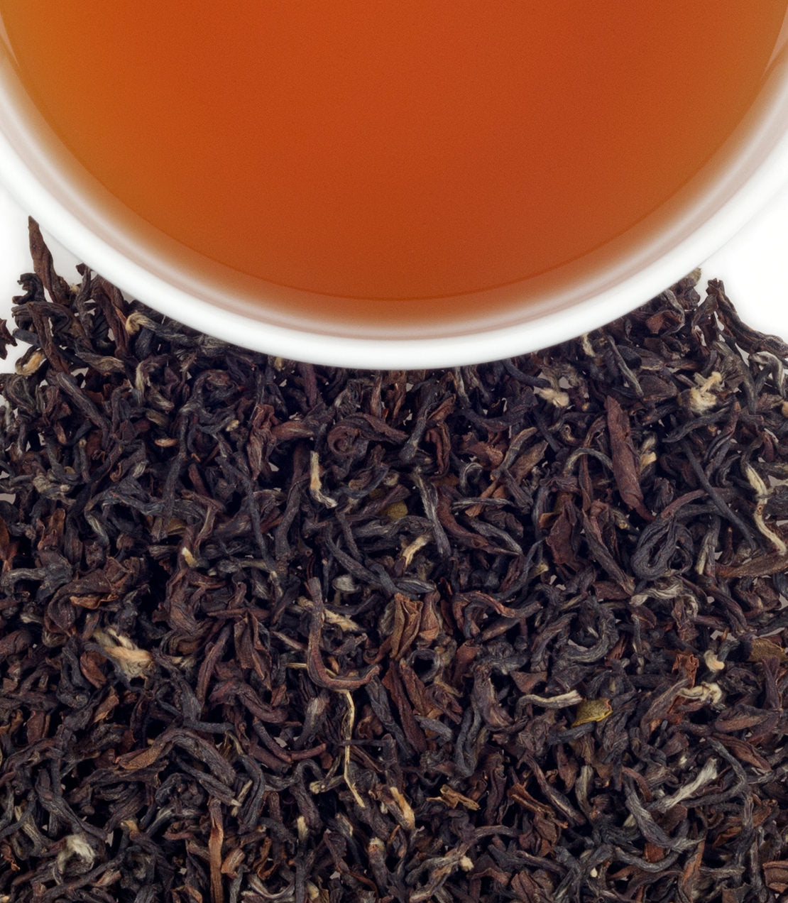 Loose black tea leaves with a cup of brewed Temi Sikkim tea, showcasing rich color and texture.