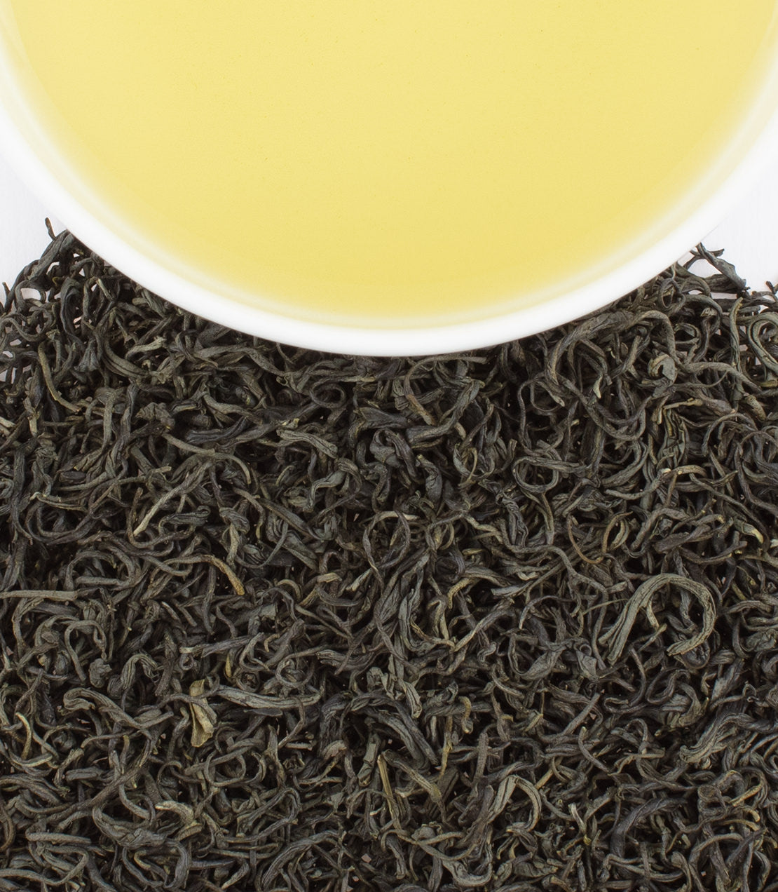 Vietnamese Tra Xanh green tea leaves with a cup of brewed tea, showcasing vibrant color and rich texture.