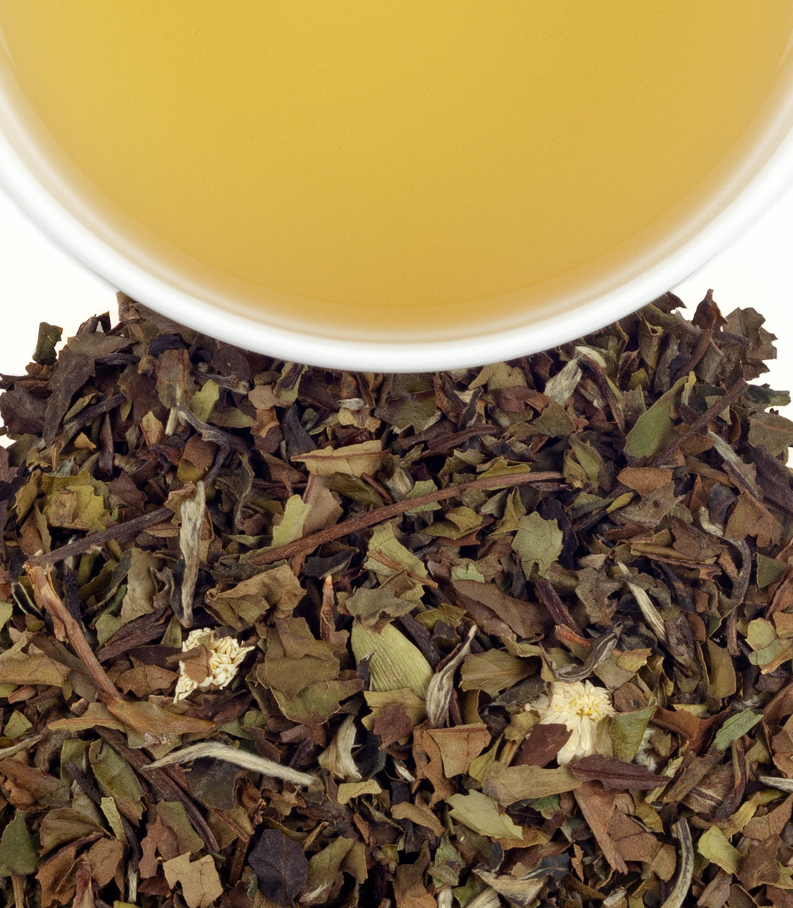 A close-up of loose leaf tea blend with dried herbs and a cup of brewed tea above it, showcasing a warm yellow hue.