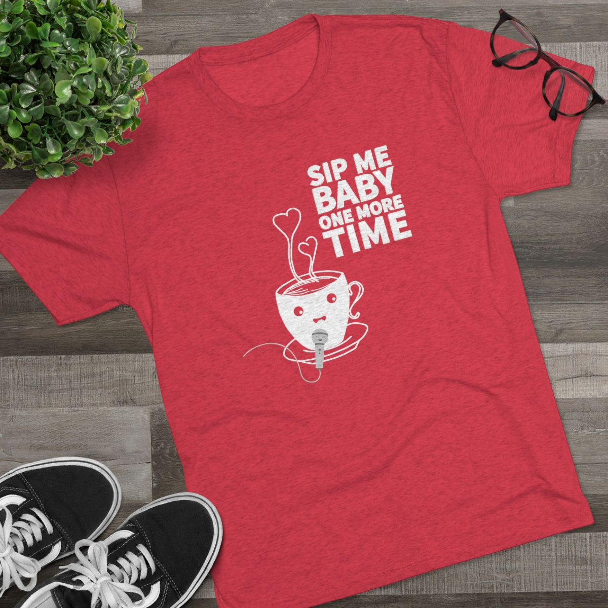 Red graphic tee featuring a playful coffee cup design with the text "Sip Me Baby One More Time." Perfect for coffee lovers.
