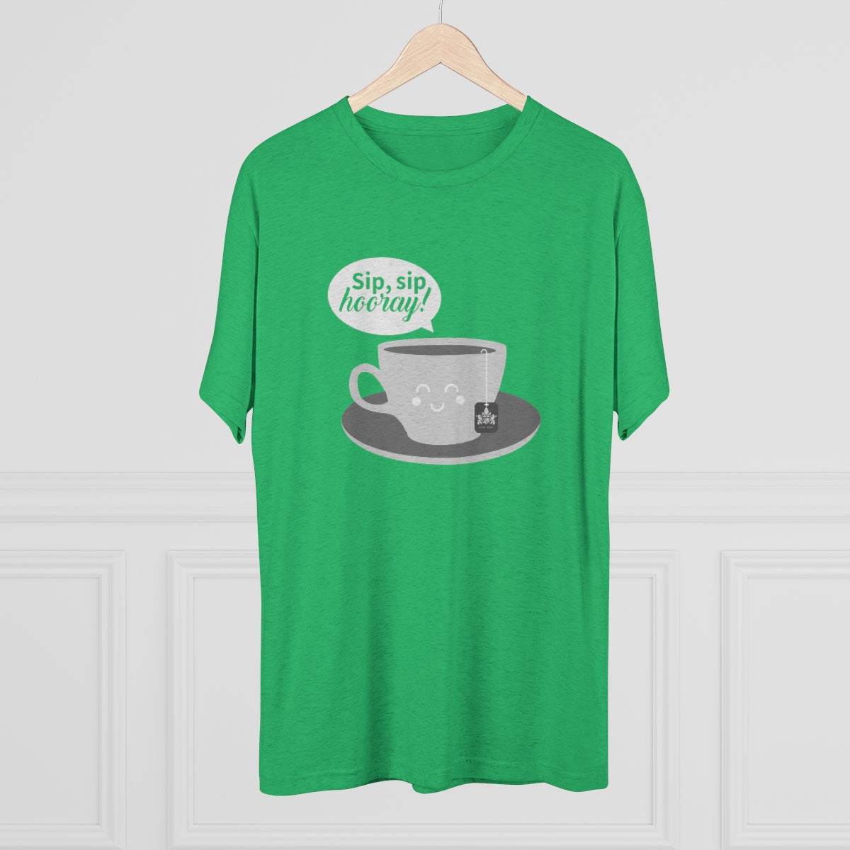 Green graphic tee featuring a smiling coffee cup and the text "Sip, sip, hooray!" on a gray saucer.