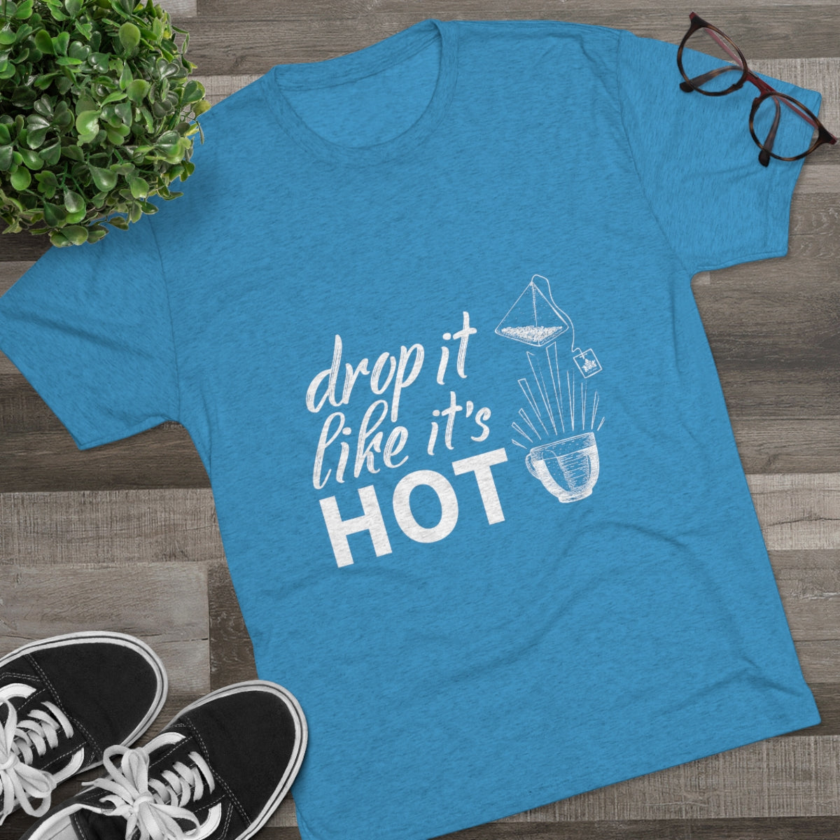 Blue graphic tee featuring the phrase "drop it like it's HOT" with a playful design of a teabag and cup.