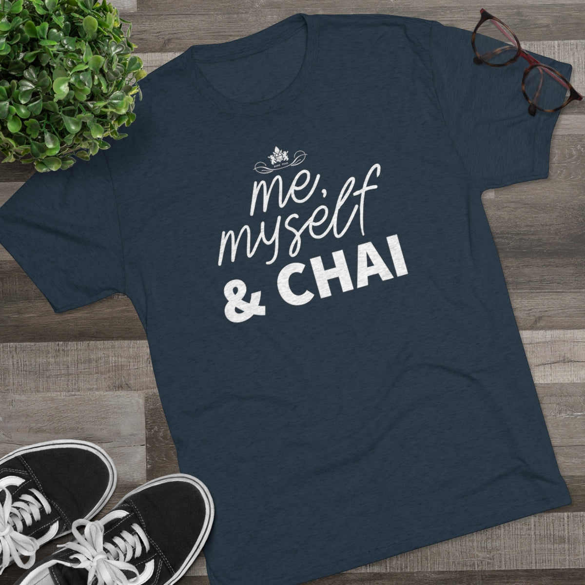 Navy graphic tee featuring the text "me, myself & CHAI" in white, styled with casual sneakers and glasses.