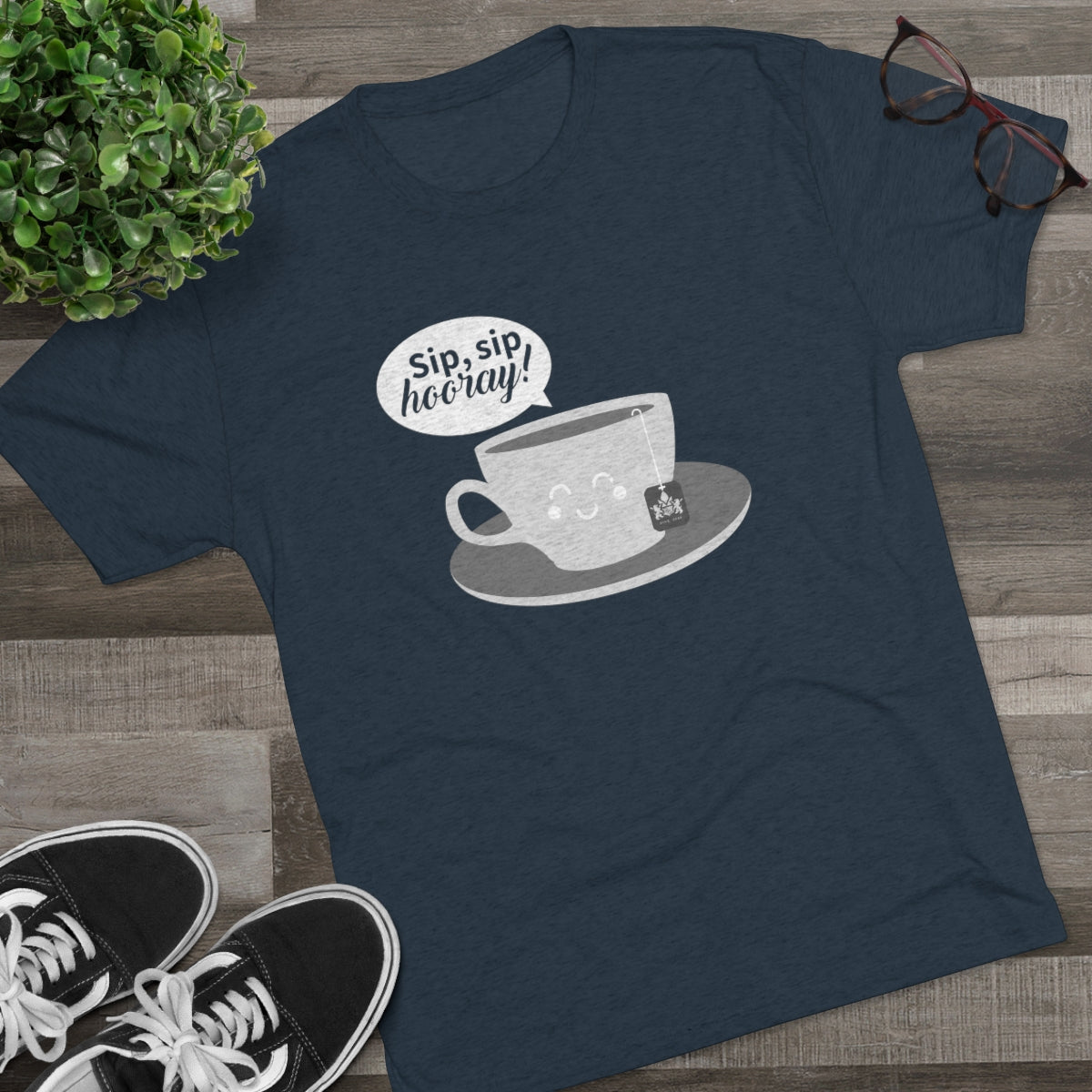 Navy graphic tee featuring a smiling teacup with the text "Sip, sip, hooray!" and a tea bag on a saucer.