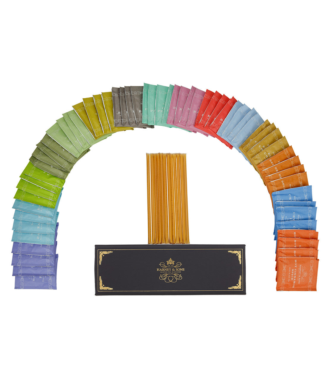 Colorful assortment of teabags and honey sticks arranged in an arc, displayed with a black sampler box.