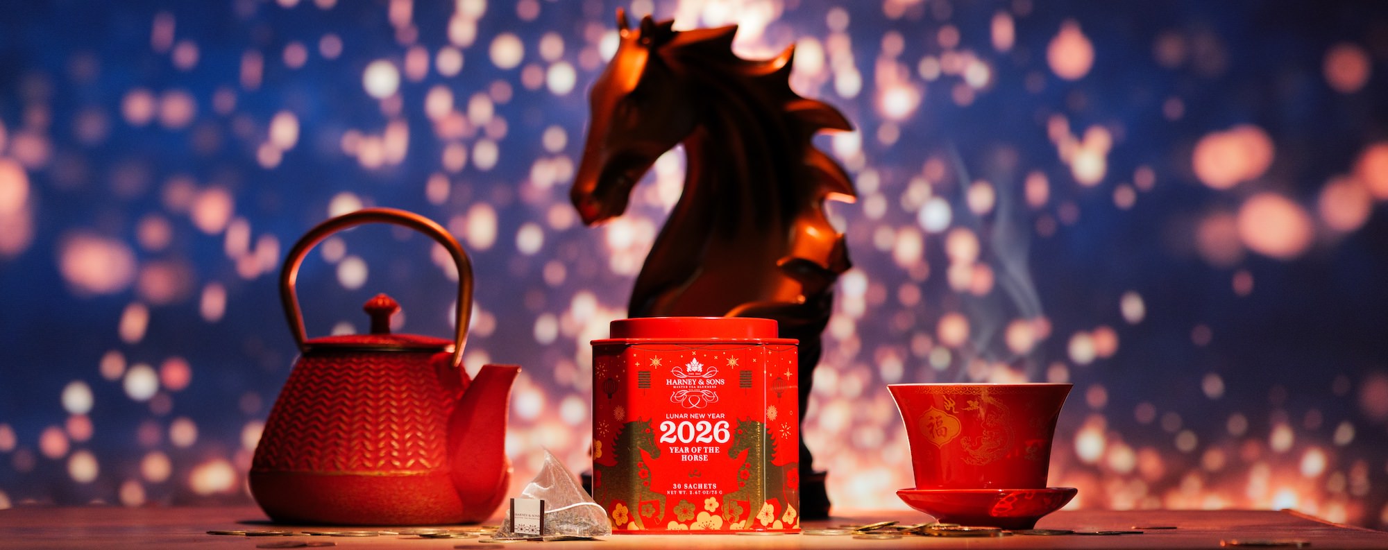 Tea set with horse statue and 2026 year of the horse lunar new year tea tin against a bokeh background.