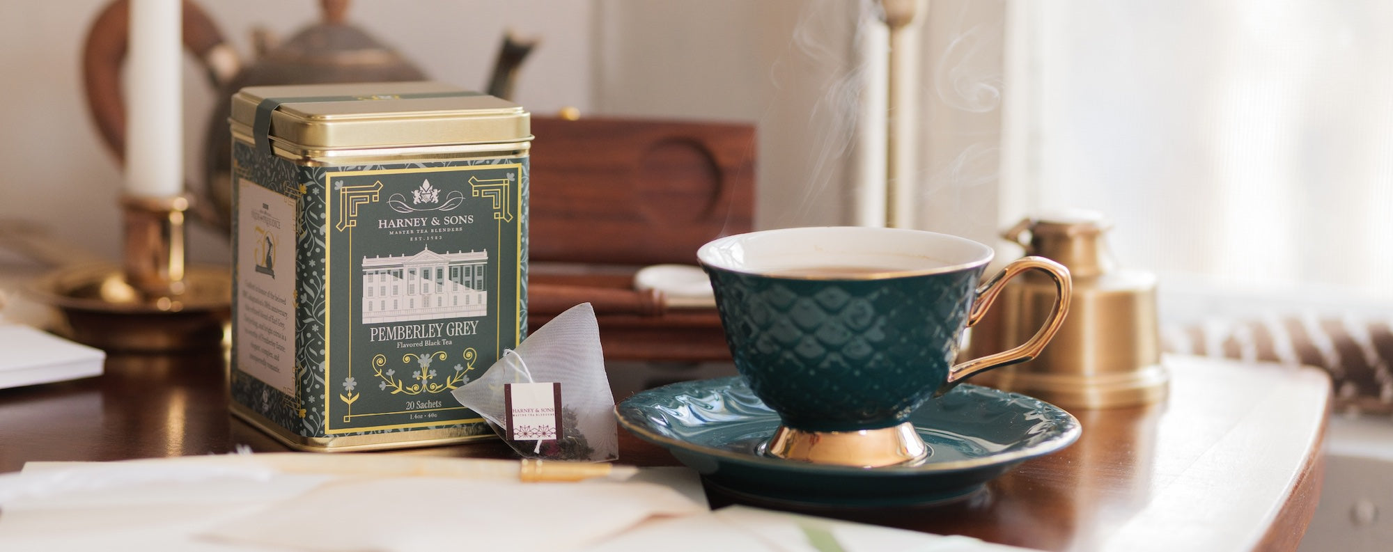 Tea cup and Pemberley Grey tea tin on a table with a blurred background.