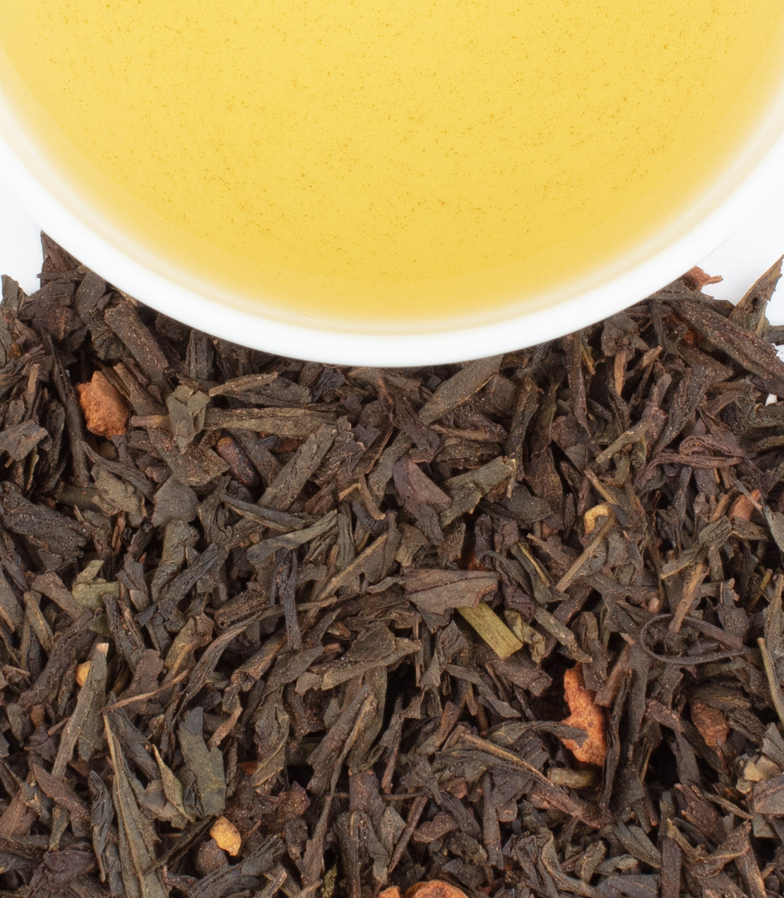 Cinnamon Apple Spice tea with loose leaves and brewed tea in a cup, showcasing rich flavors and aromas.