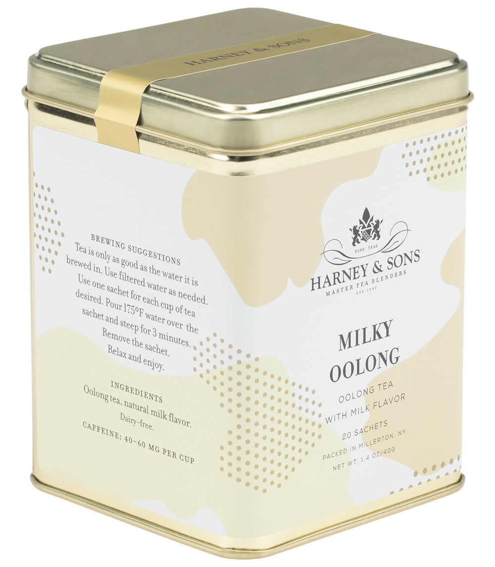 Tin of Milky Oolong tea sachets displayed with the lid open, showing individually wrapped tea bags inside.