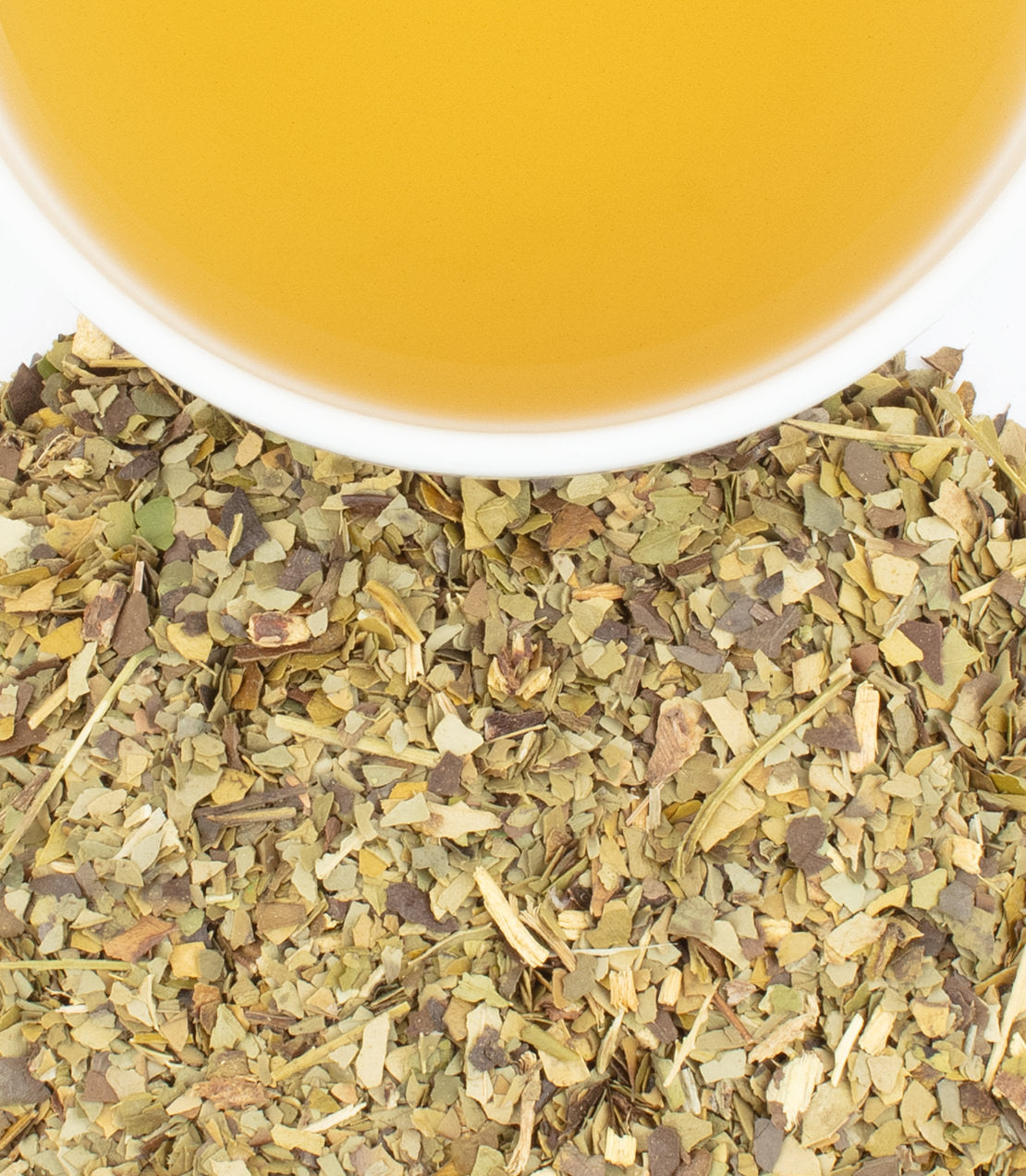 Yerba mate licorice tea leaves with brewed tea in a white cup, showcasing earthy tones and herbal textures.
