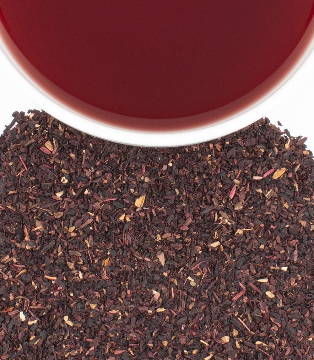 Box of 20 premium hibiscus teabags with dried hibiscus flowers and brewed tea in a cup.