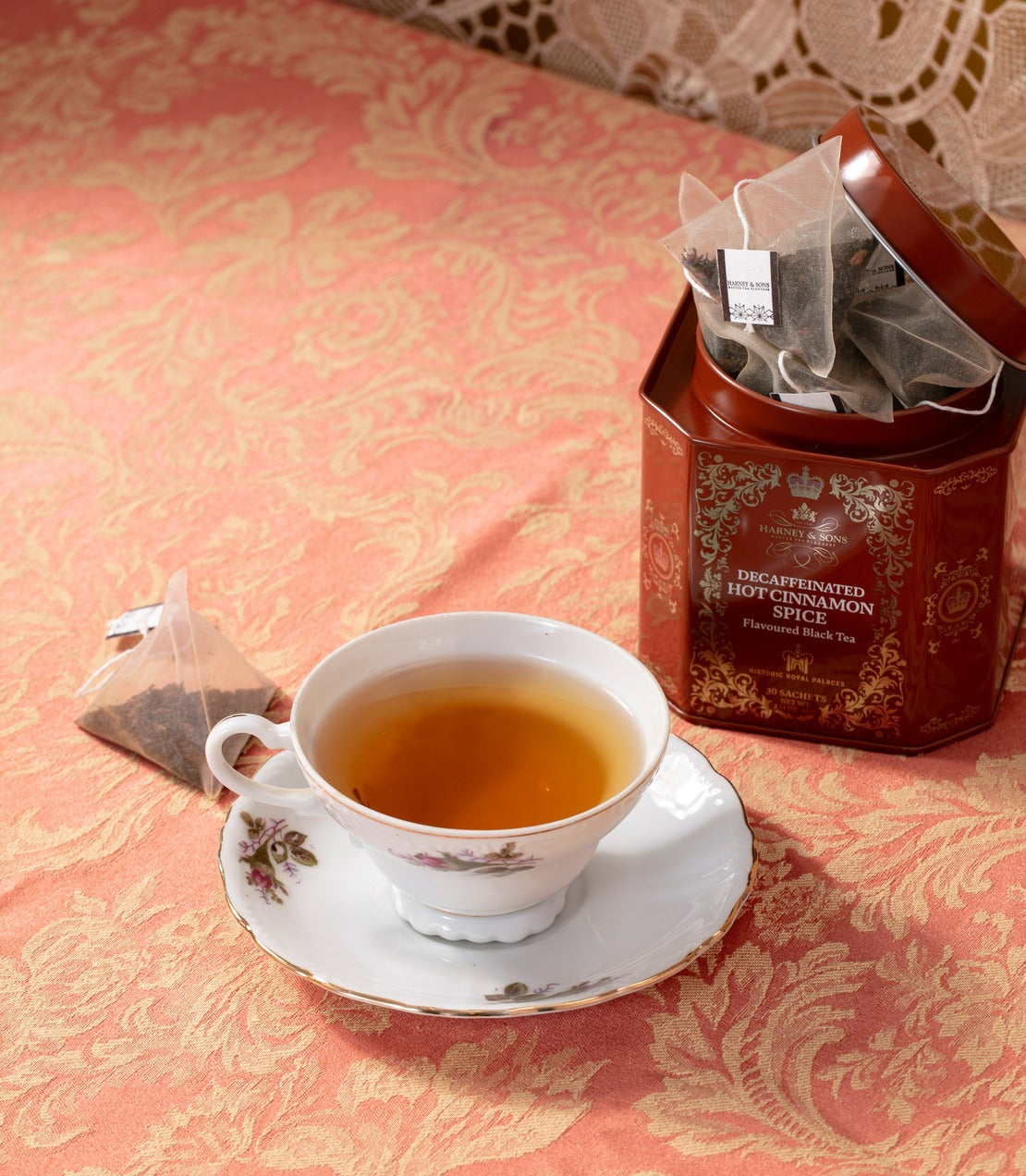 Harney & Sons Fine Teas- Decaf Hot Cinnamon Spice- Historic Royal Palaces tin of 30 sachets with a tea sachet and a cup of brewed tea