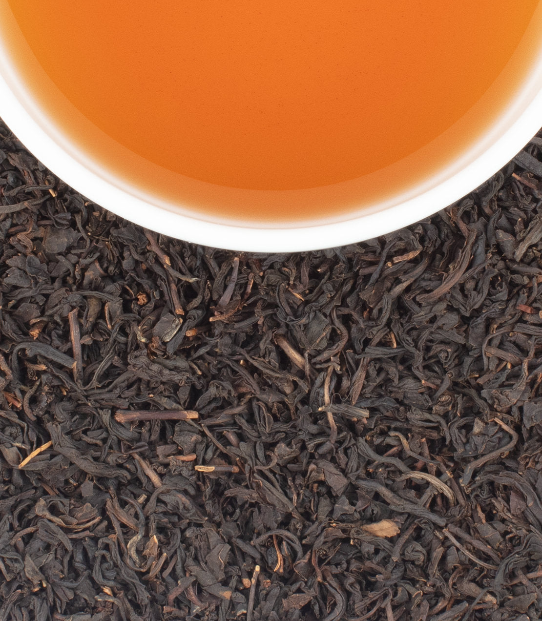 Freshly brewed Boston tea in a white cup, surrounded by loose Boston tea leaves.