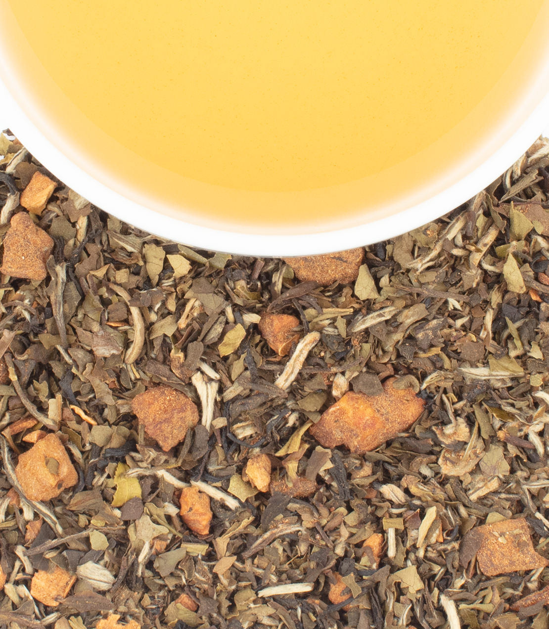Freshly brewed Heirloom Bartlett Pear tea in a white cup, surrounded by herbal ingredients