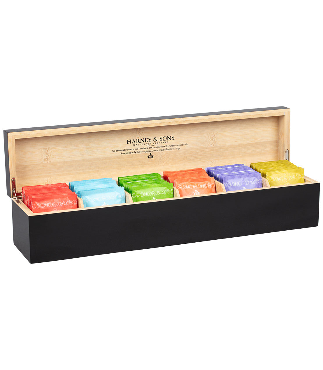 An open wooden tea box with colorful tea bags arranged in compartments, branded with "Harney & Sons." Black on the outside, natural wood on the inside