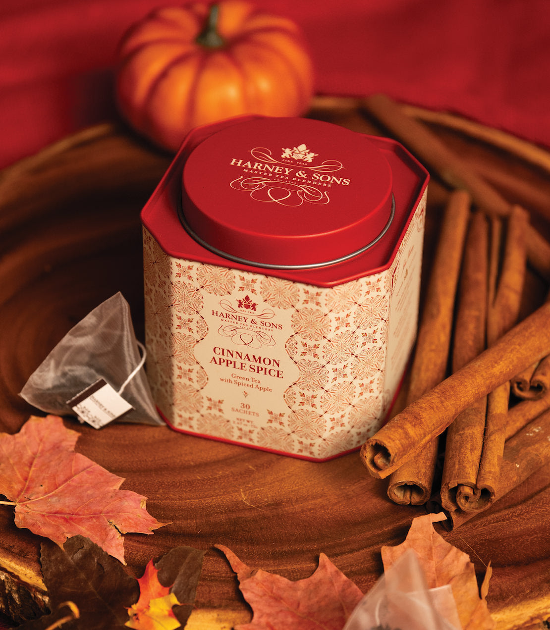 Cinnamon Apple Spice tea tin with 30 sachets, surrounded by cinnamon sticks and autumn leaves. Perfect for cozy moments.