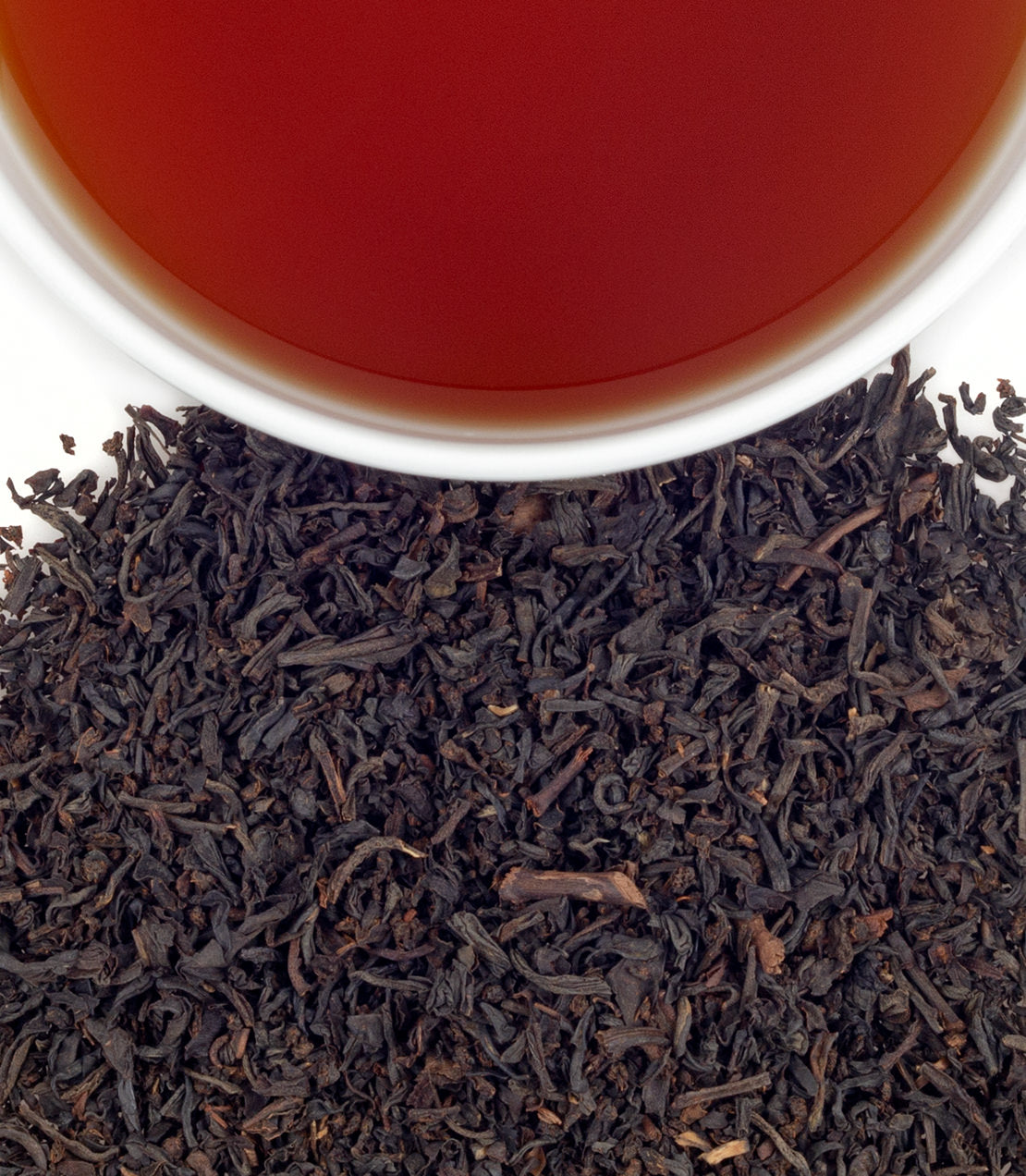 RMS Titanic Blend tea sachets in a tin, with loose tea leaves and brewed tea in a cup.