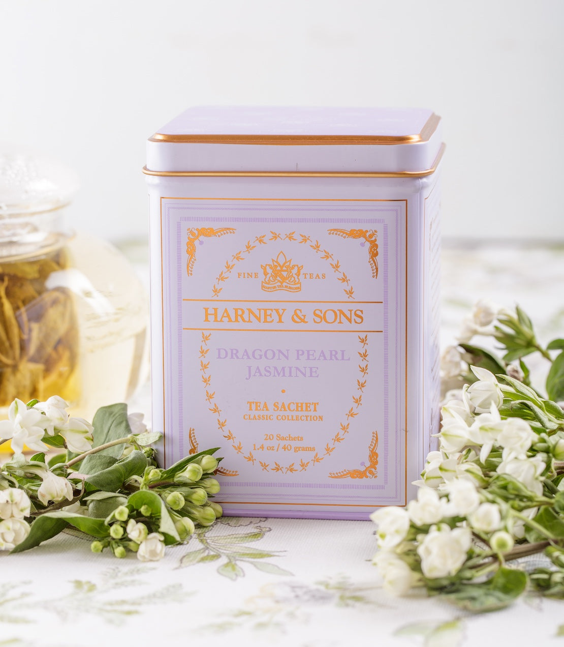 Harney & Sons Dragon Pearl Jasmine tea tin with floral decorations on a light background