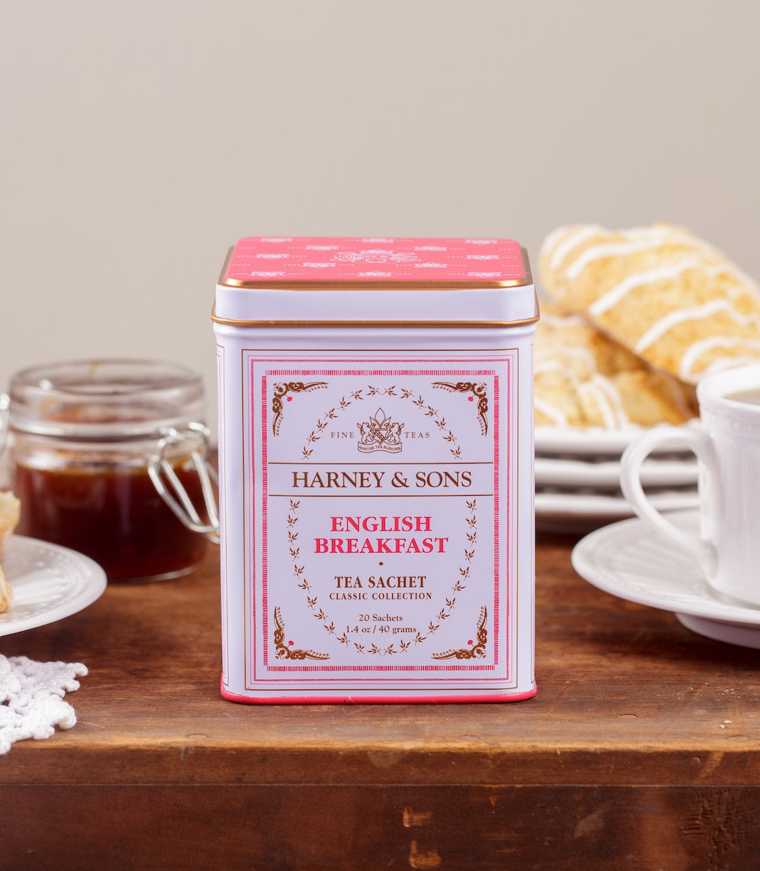 Harney & Sons English Breakfast tea tin on a wooden table with a cup of tea and scones.