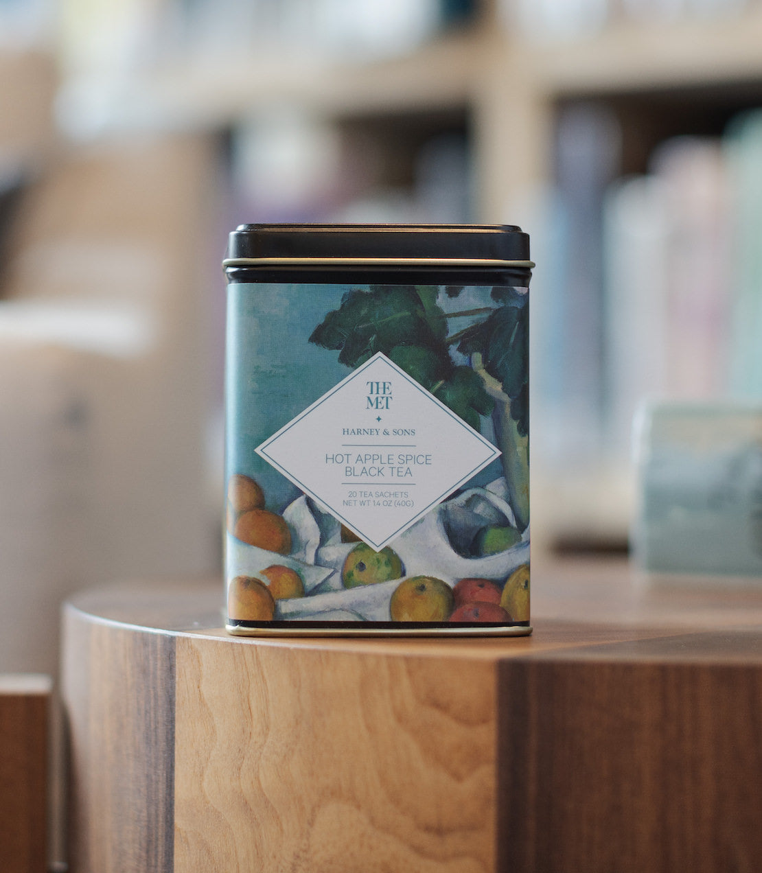 Tin of Hot Apple Spice Black Tea with 20 sachets, featuring a colorful fruit design on the label.