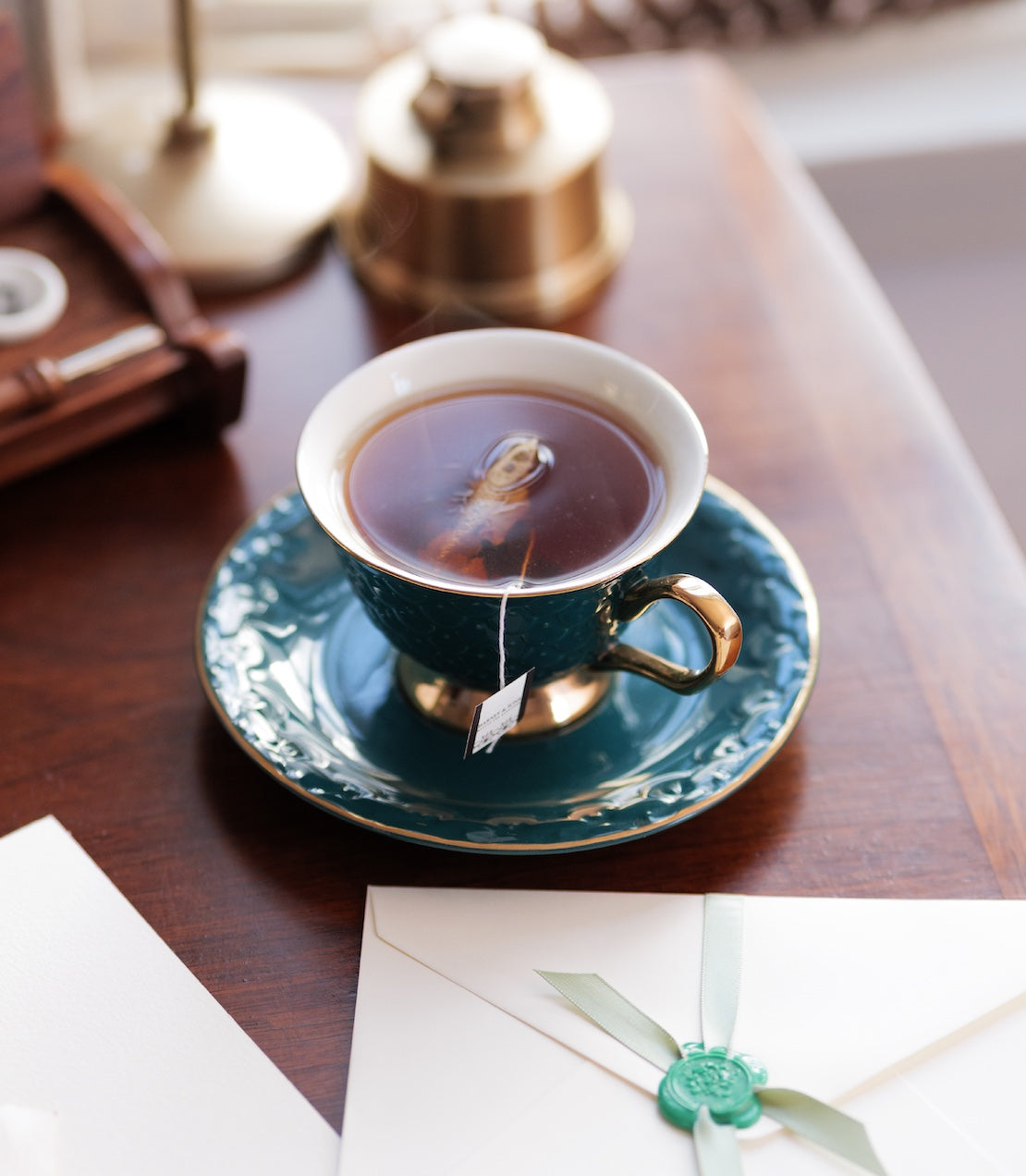 Tea cup with saucer on a wooden table with a tea sachet.