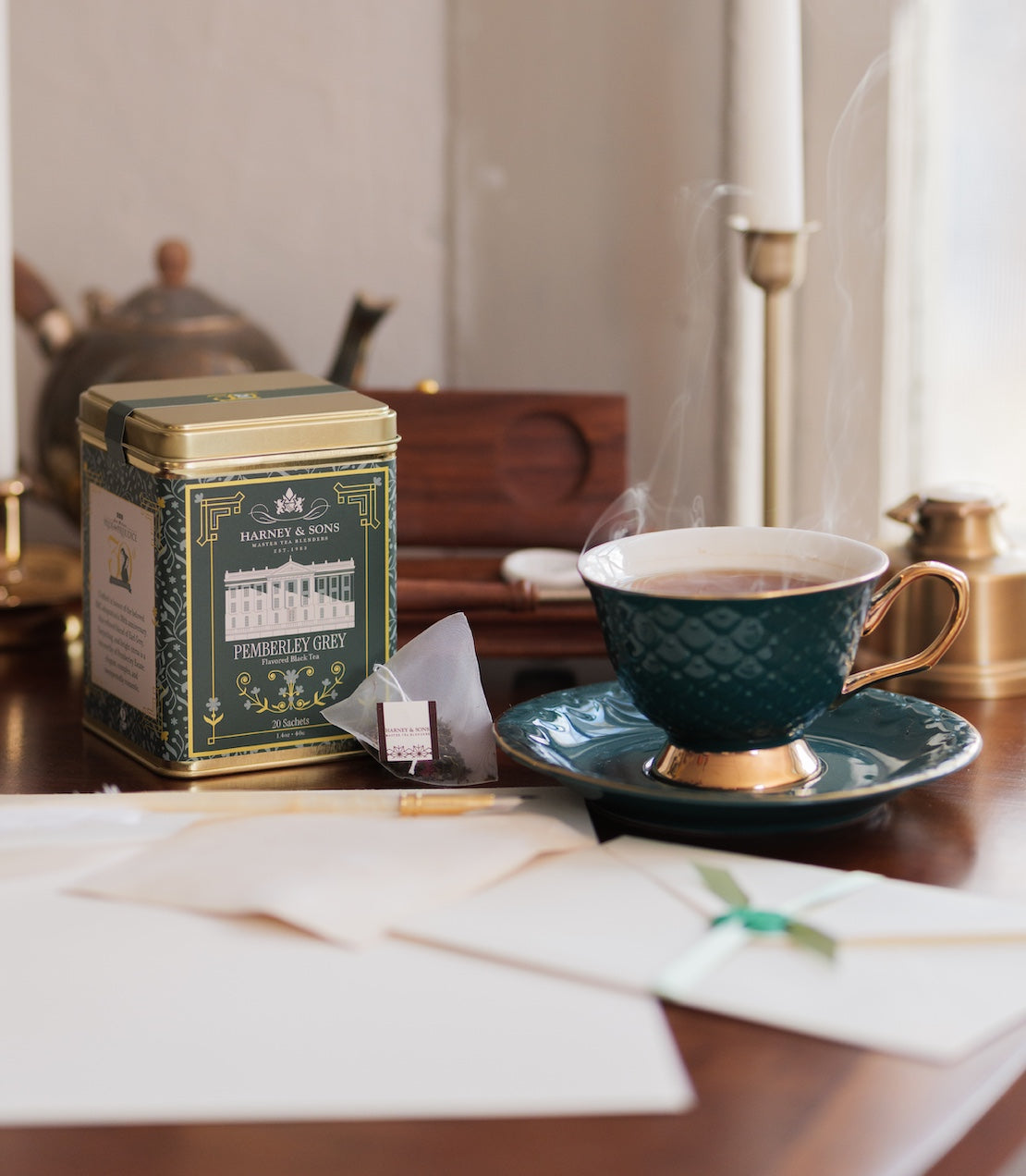 Tea cup and saucer with Pemberley Grey tea tin on a table.