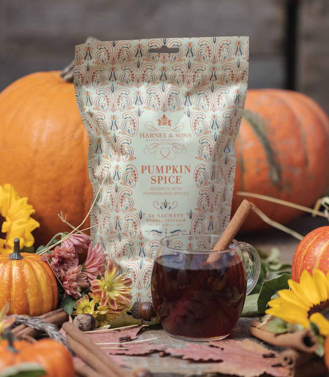 Bag of 50 Pumpkin Spice sachets by Harney & Sons, surrounded by pumpkins and autumn flowers.