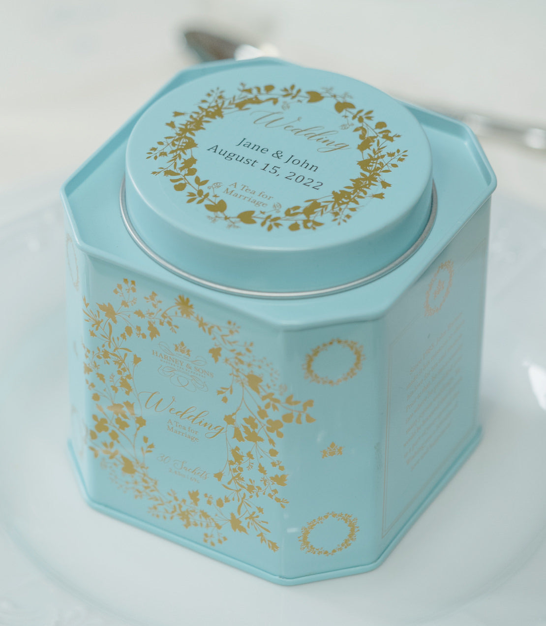 Personalized wedding tea tin featuring gold floral design, containing 30 sachets, dated August 15, 2022.