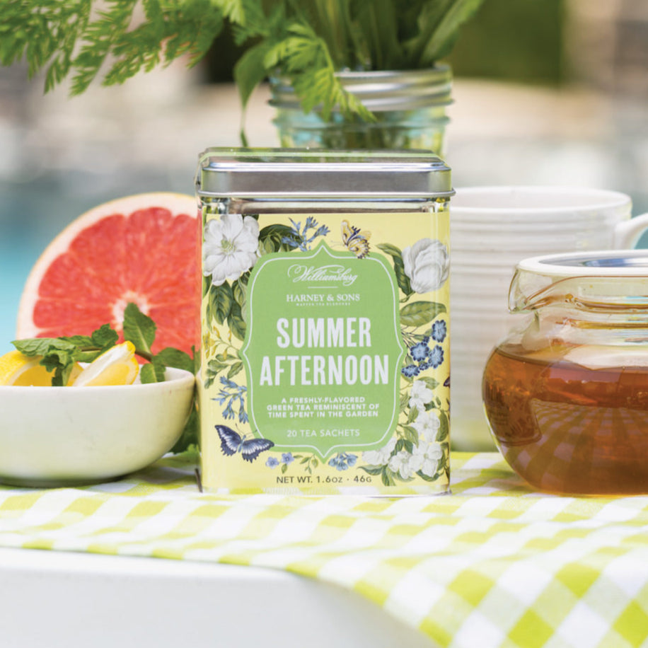 Tin of 20 sachets of Williamsburg Summer Afternoon Tea, surrounded by fresh flowers and a glass teapot.