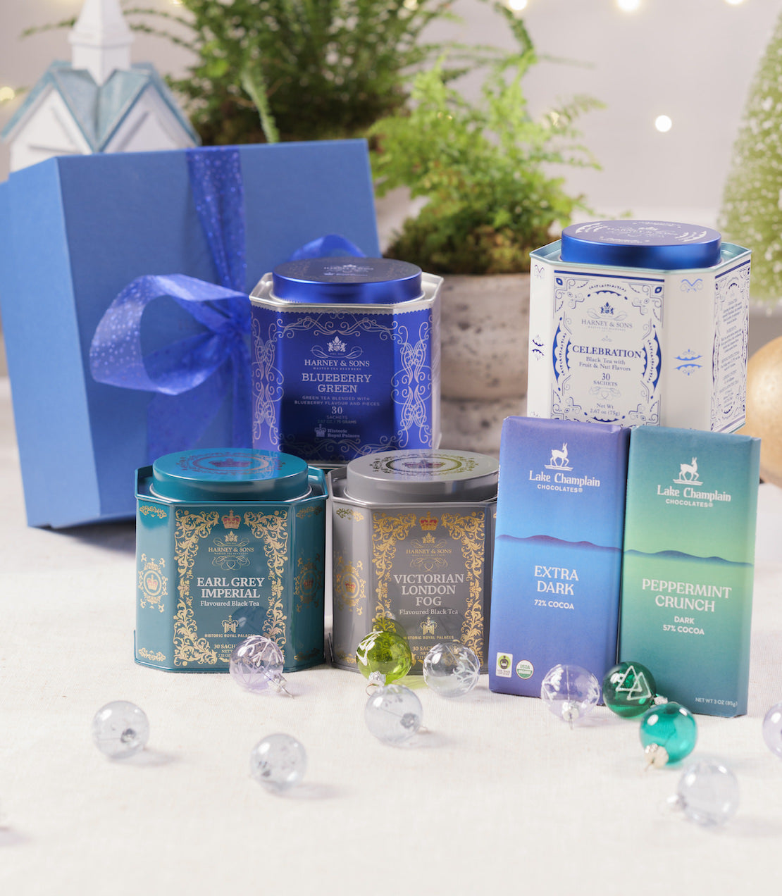 Collection of tea tins and packaging on a white surface with decorative elements.