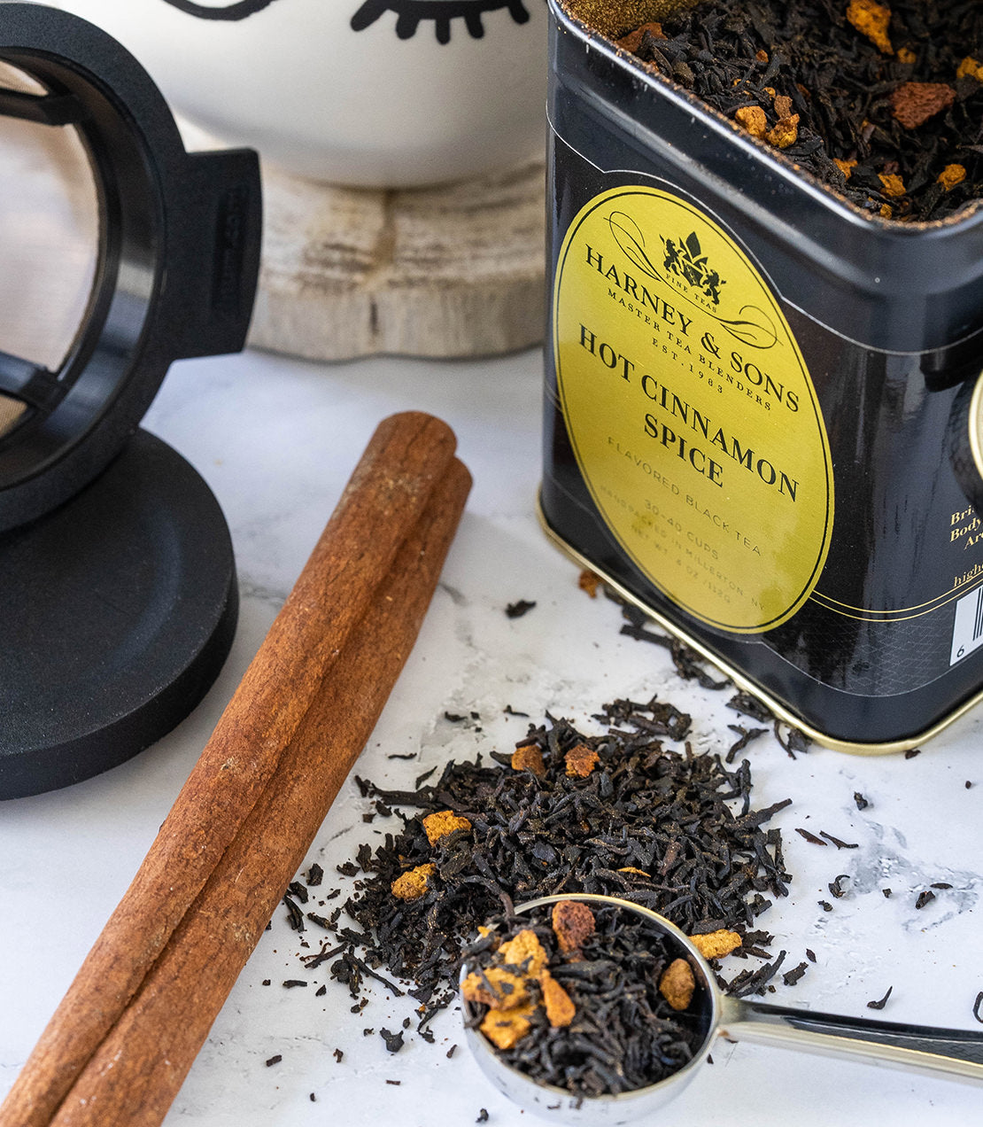 "Finest Tea Starter Kit featuring Harney & Sons Hot Cinnamon Spice tea, cinnamon sticks, and a tea infuser.
