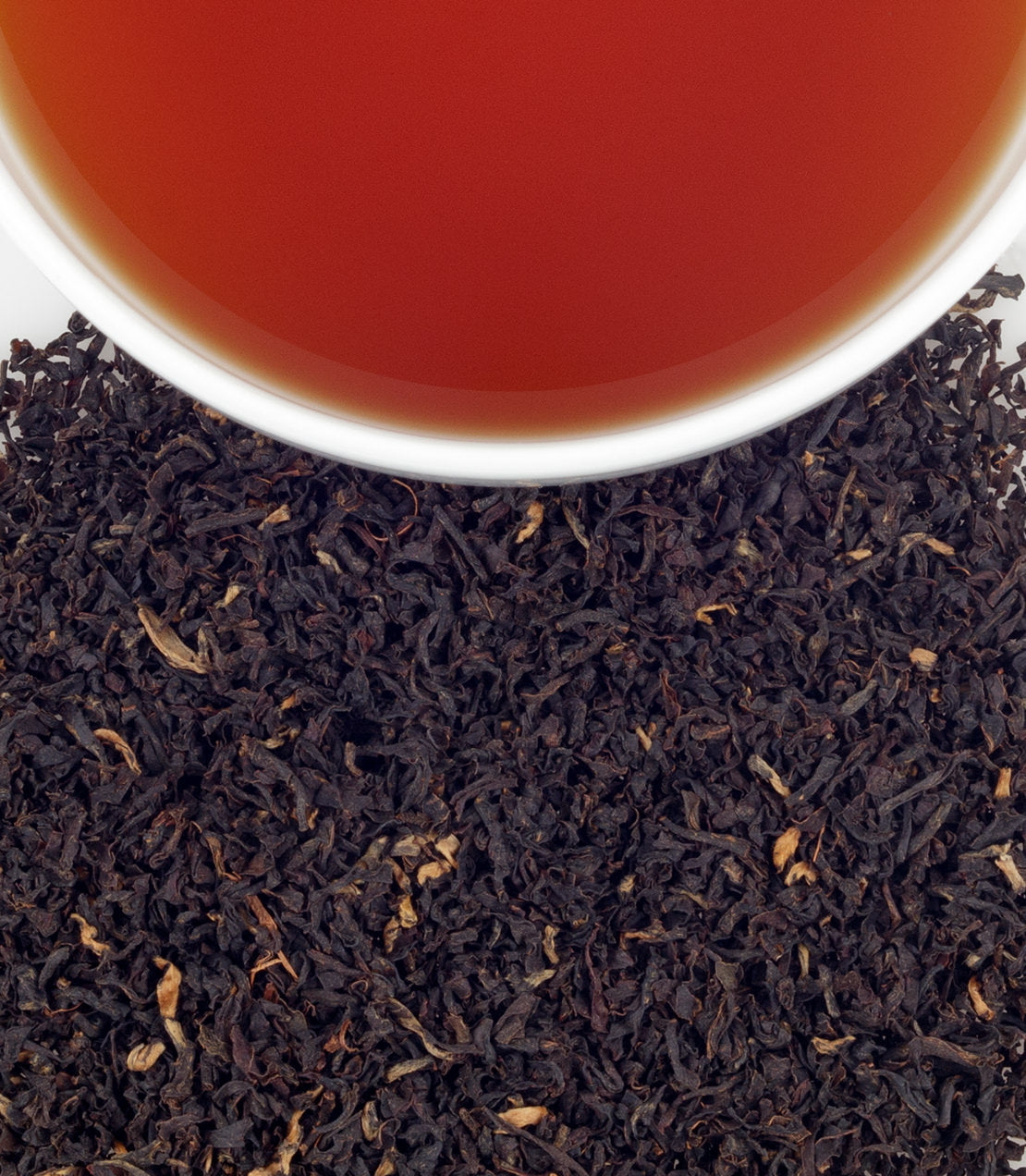 Kenya Milima tea leaves with a cup of brewed tea, showcasing rich color and texture.