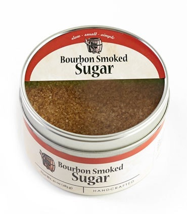Bourbon Barrel Foods Bourbon Smoked Sugar in a round tin, showcasing its rich brown color and handcrafted label.