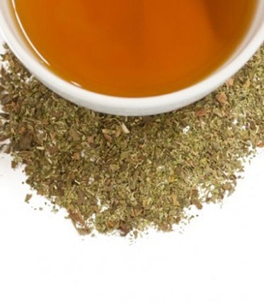Mint Verbena tea sachets, 50-count bag, with brewed tea and loose herbs displayed. Refreshing herbal blend.